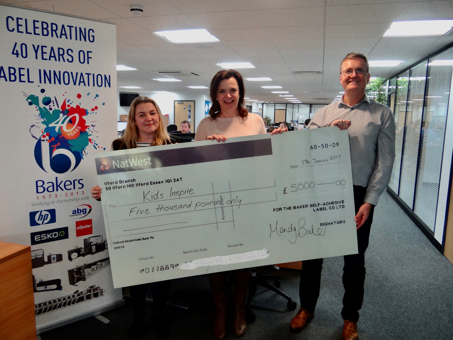 Baker labels present cheque to Kids Inspire