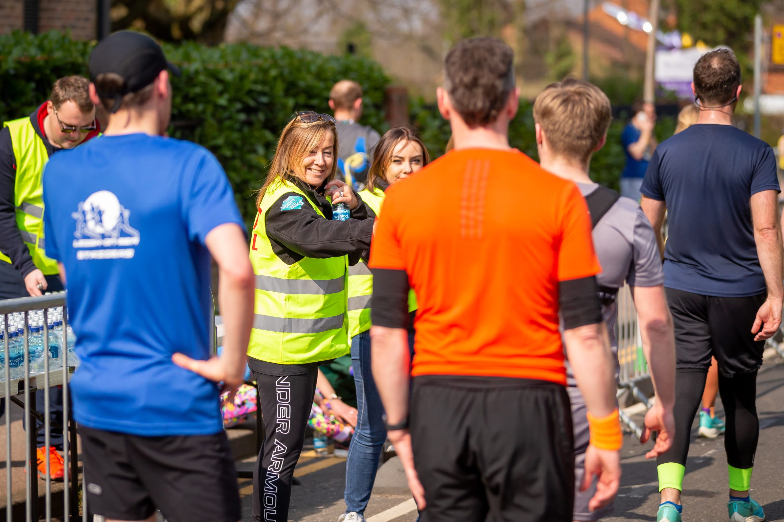 Volunteers give out water to half marathon finishers