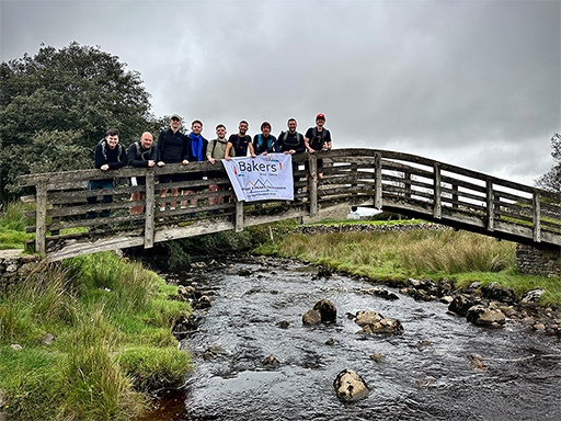 Group of hikers during yorkshire 3 peaks on a bridge with a flag