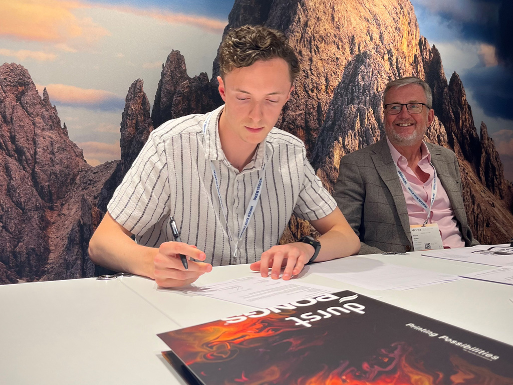 Tom Baker signs the deal for the Durst inkjet at Drupa 2024